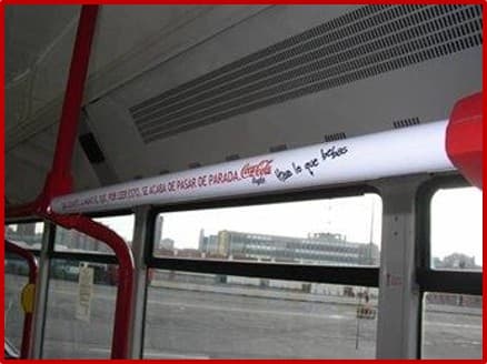 Publicidad de Coca-Cola en barra interior de bus urbano, promoción con mensaje 'Pásala bien'